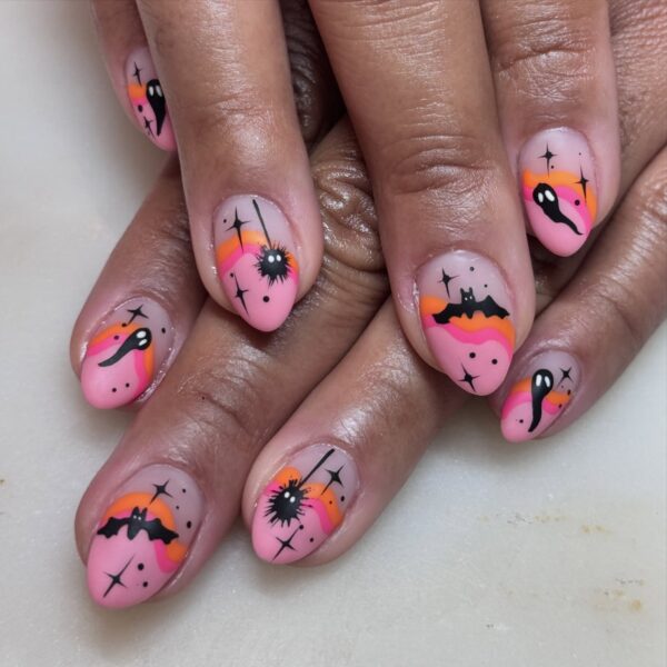Neon pink and orange halloween nails with black accents