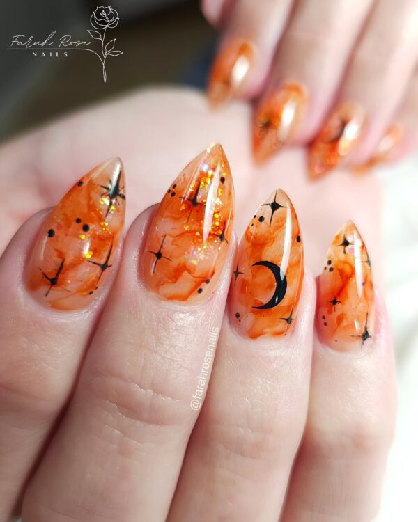 Orange marble Halloween nails with black moon and stars